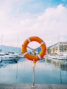 A colorful Lifebuoy is at the Marina among Boats under Blue Sky photo