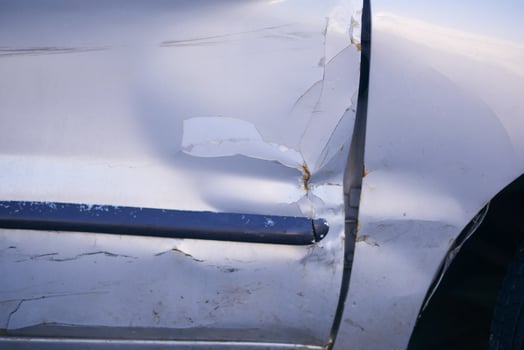 Car damage with visible scratches and dents on the door panel photo