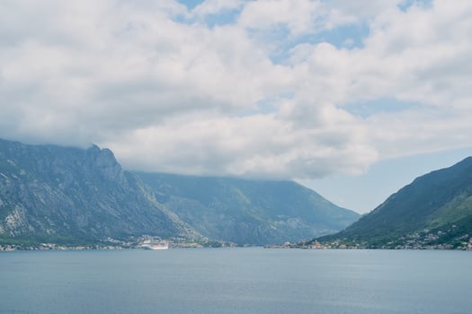 Large cruise ship sails in the Bay of Kotor along a mountain ridge in the fog. Montenegro photo