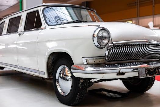 An old white car is on display in a museum photo