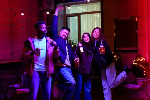 Friends enjoying an evening celebration with drinks at a colorful outdoor gathering in an urban setting photo