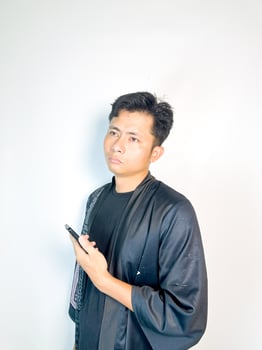 A man in black shirt holding a cell phone photo