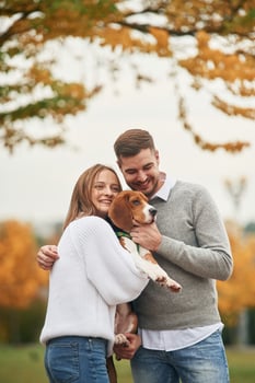 Smiling, having fun.., Lovely couple are with their cute dog outdoors photo
