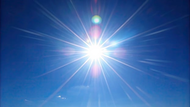 Bright sunburst with rays against a clear sky. photo