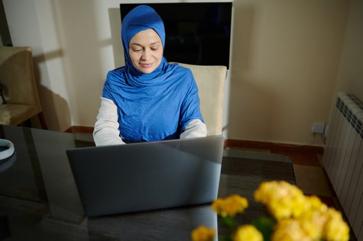 Professional Muslim Woman Working Remotely From Home on a Laptop in a Cozy Space photo