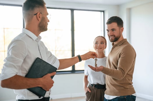 Giving,, the keys. Realtor shows an apartment to a young couple photo