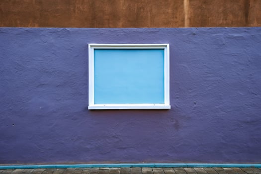 Blue window frame on a vibrant purple wall. photo