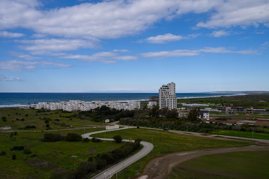 Vibrant coastal landscape showcasing modern architecture and nature under a bright blue sky in late afternoon photo