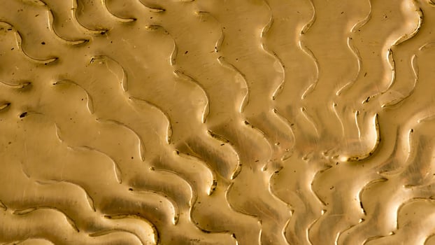 A close up of a gold surface with waves photo