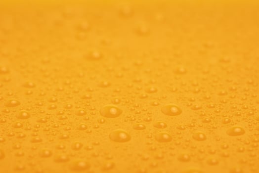 Yellow plastic background with water drops. Abstract yellow background. photo