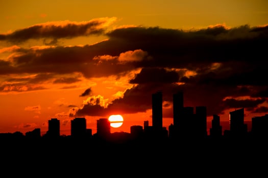 sunset on a cloudy day among the big buildings of the city photo