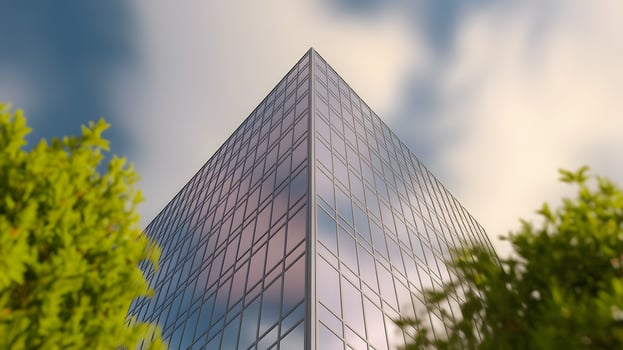 Pyramid-shaped modern glass skyscraper surrounded by greenery photo