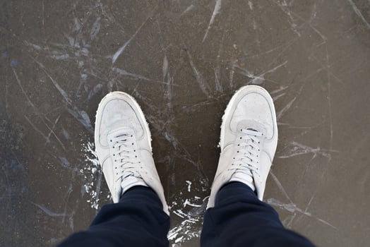A man stands on cracked ice, outdoors, top view. photo