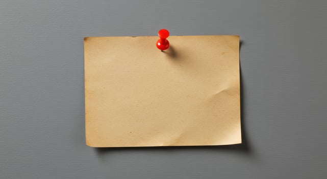 Blank vintage brown paper note pinned to gray wall, suitable for advertisements, announcements, reminders, or as a background for quotes or text overlays. photo