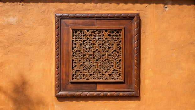 Ornate wooden frame on an orange textured wall. photo