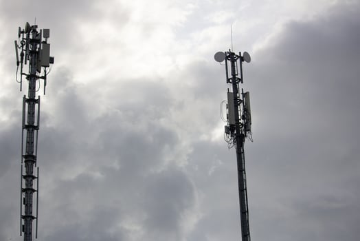 Two telecommunication towers under a cloudy sky, symbolizing connectivity, communication, and modern infrastructure technology photo