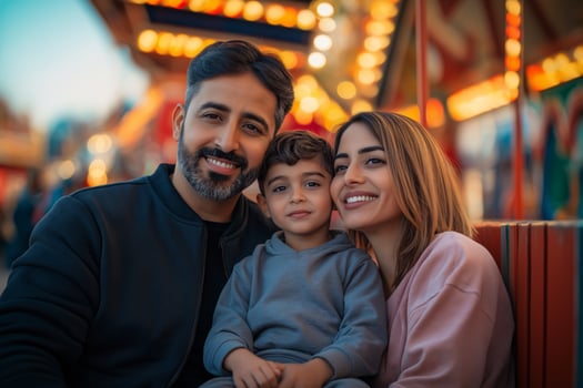 Happy Family Portrait at Amusement Park Middle Eastern Parents with Child photo