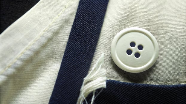 Close-Up of White Button on Blue and White Fabric with Fine Details photo