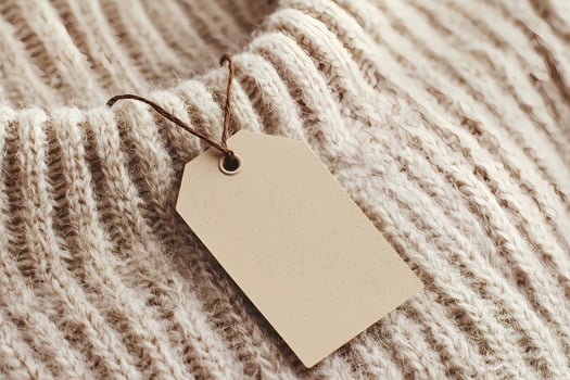 Blank beige clothing label on cozy knitted sweater photo