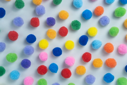 Colorful Fluffy Pom Poms Scattered on White Background photo
