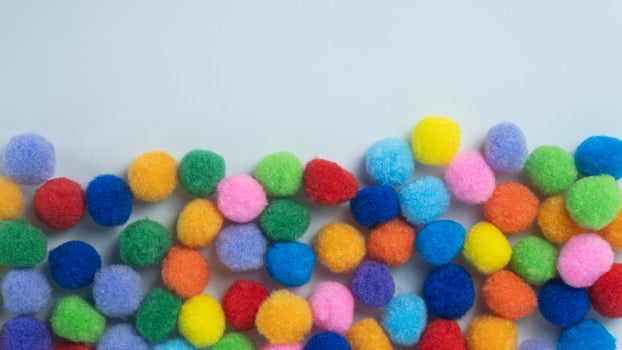 Colorful Pom Poms Lined at Bottom with Copy space on White Background photo