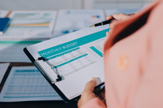 A woman is holding a clipboard with a financial budget on it photo