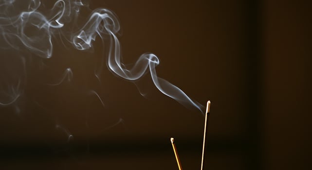 Aromatic Incense Sticks Burning with Delicate Smoke Against Dark Backdrop photo