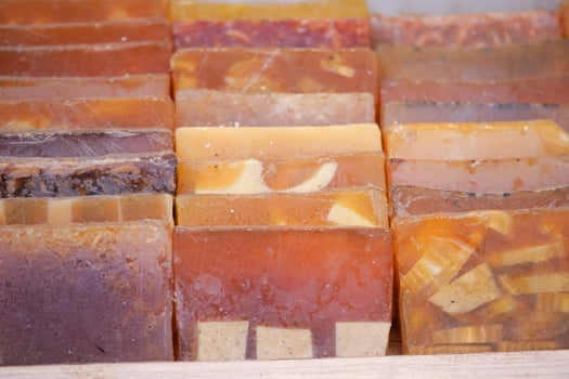 Colorful handmade soaps arranged for sale at a market stall photo
