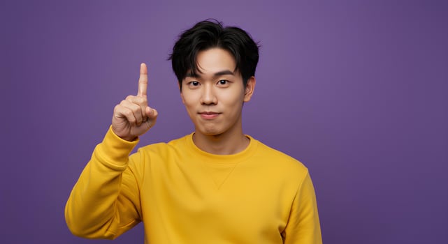 Man in Yellow Sweatshirt Pointing Up Against Purple Background photo