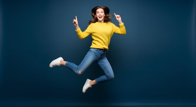 Energetic young woman jumping in a vibrant yellow sweater and jeans. photo