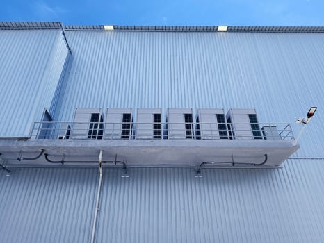 There are numerous air conditioners installed on the exterior of the building photo