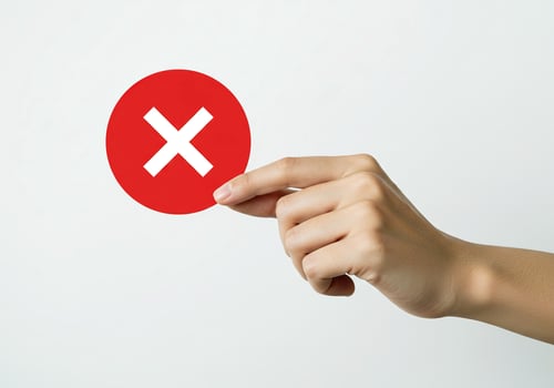 A person pointing at a red circle with an x on it photo