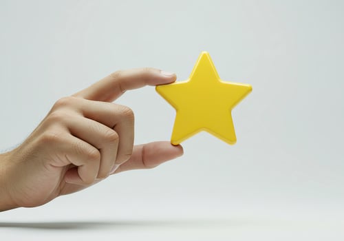 A hand holding a yellow star on a white background photo