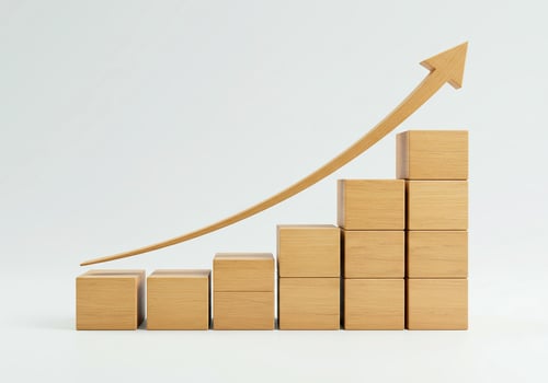 A wooden arrow going up from wooden blocks photo