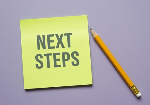 Next steps on yellow sticky note with pencil on purple background photo