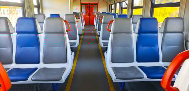 Carriage of a city electric train with blue and gray seats. Interior of a passenger train. Empty seats in a carriage. Intercity. photo