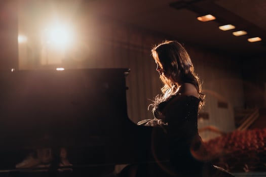 elegant Woman at the Piano Under Theater Lights photo