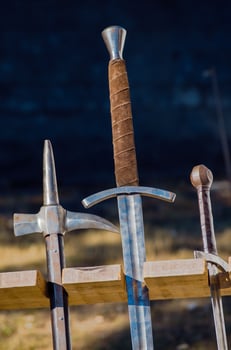 ancient arms displayed vertically in a wooden stand in a reenactment medieval event medieval combat weapons photo