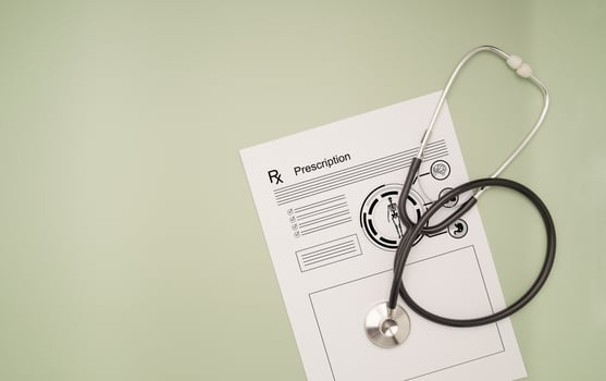 Top view of a stethoscope over the medical prescription sheet on a green background photo