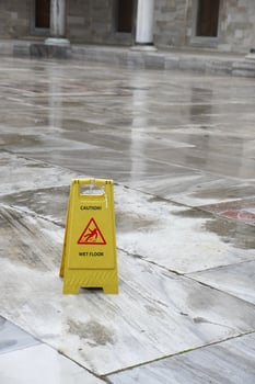 Caution sign indicating wet floor in a public building interior photo