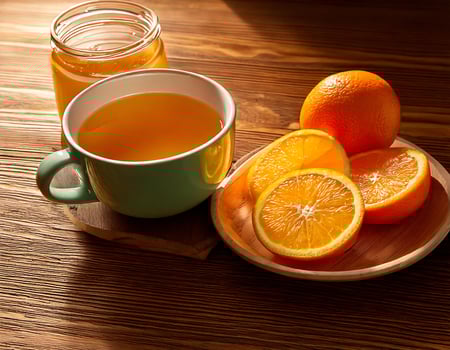 A cup of tea and a bowl of orange juice photo