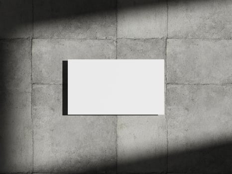 Business card mockup placed on concrete surface with soft shadows, perfect for showcasing branding and design concepts. photo