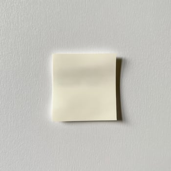 Single Blank Crumpled Sticky Note on Textured Grey White Surface photo