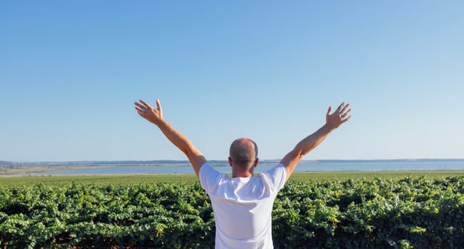 A young man in a white T-shirt spreads his arms and looks at the sea coast. A middle-aged male stands with his back and enjoys the natural scenery. photo