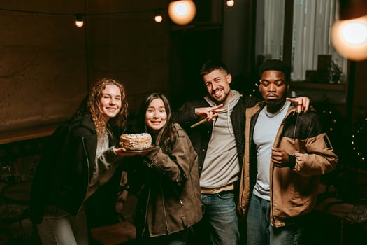 Friends celebrate with cake in cozy indoor space during evening gathering photo