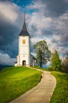 Rural pathway and Saint Primoz church on the hill, Slovenia photo