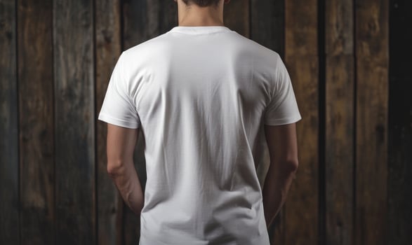 back view of a man wearing a white t - shirt against a wooden background photo