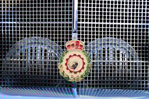 Cartagena, Spain - April 3, 2024 . Vintage car radiator grille emblem with crown and laurel design. High quality photo