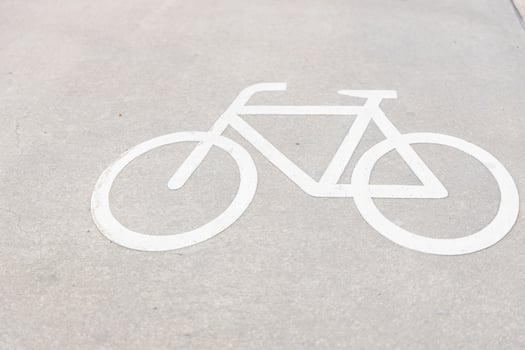 Bicycle sign on the asphalt path on the city street in the summer afternoon photo