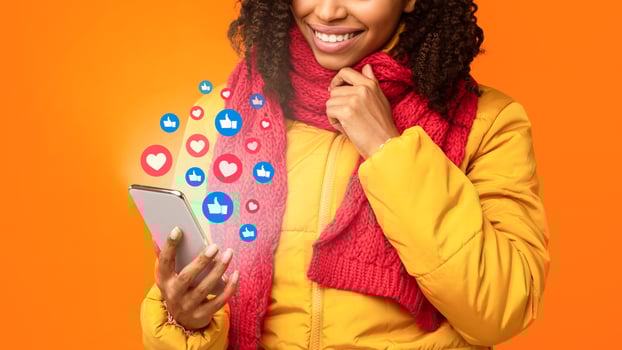 Unrecognizable Black Lady Using Cellphone Networking Chatting In Social Media, Commenting And Texting In Mobile App Posing Over Yellow Studio Background. Collage With Like Buttons And Hearts, Cropped photo